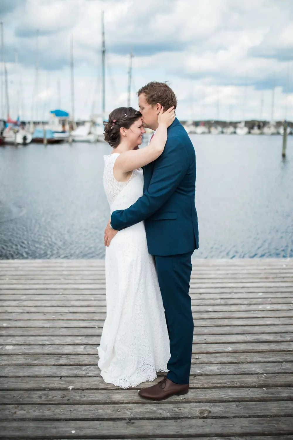 Bride and groom embracing on a jetty